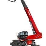 A red Magni RTH 10.37 rotating telescopic handler with extended stabilizers and a raised boom equipped with forks.