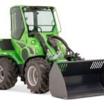 Avant 845 GT mini loader with an enclosed cabin and equipped with a bucket attachment. The green loader features large, rugged tires and is designed for heavy-duty tasks in agriculture, construction, and industrial applications.