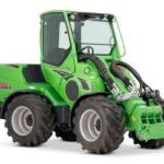 Avant 845 GT mini loader with an enclosed cabin and large rugged tires, showing the front hydraulic attachment area. The green loader is designed for heavy-duty tasks in various industries, offering versatility and powerful performance.