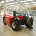 Side-front view of the Magni TH 5.8P telescopic handler in a spacious indoor facility.