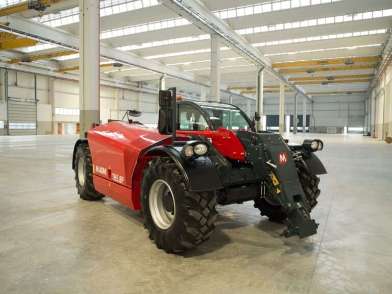 Side-front view of the Magni TH 5.8P telescopic handler in a spacious indoor facility.